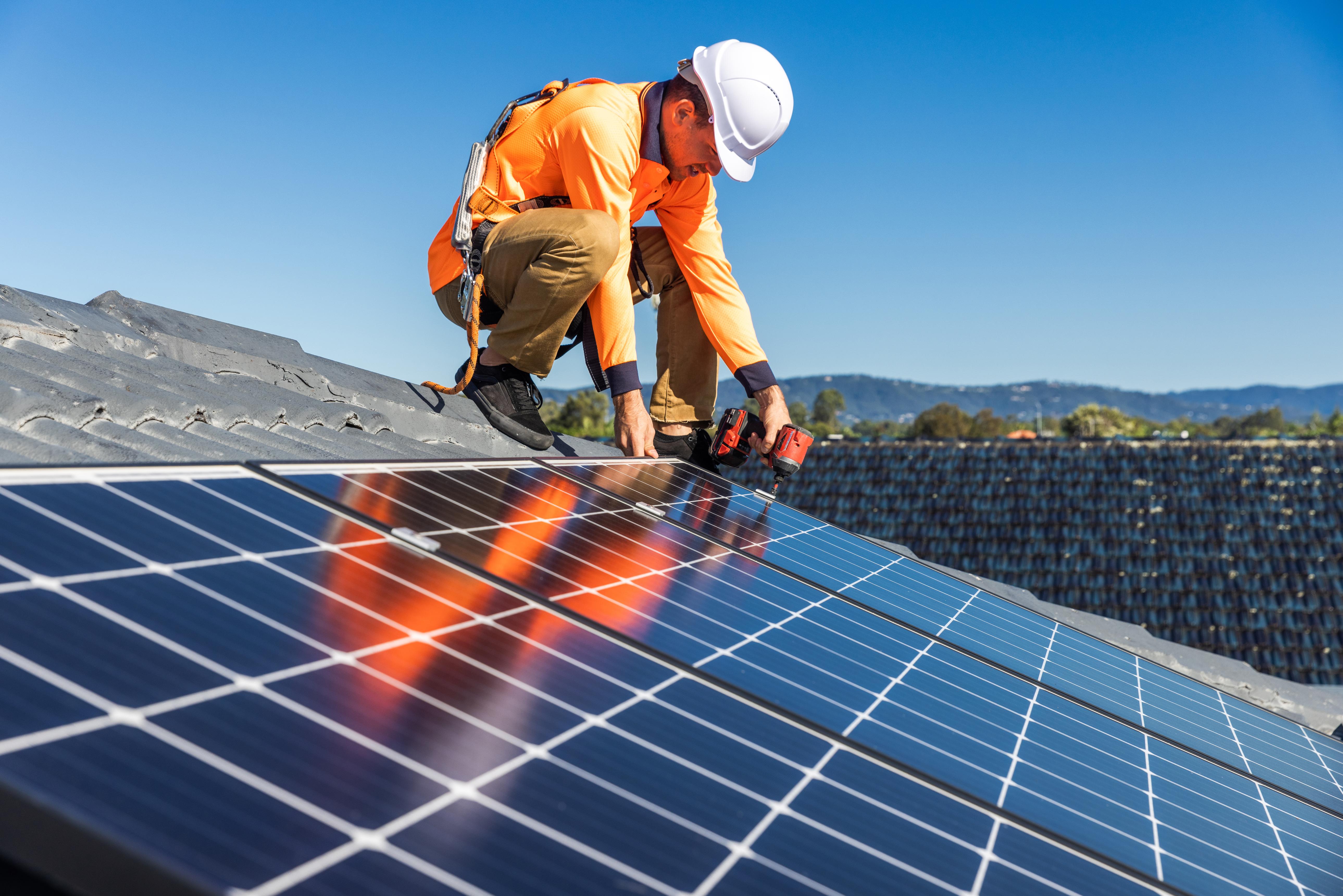 Solar panel technician installing panels
